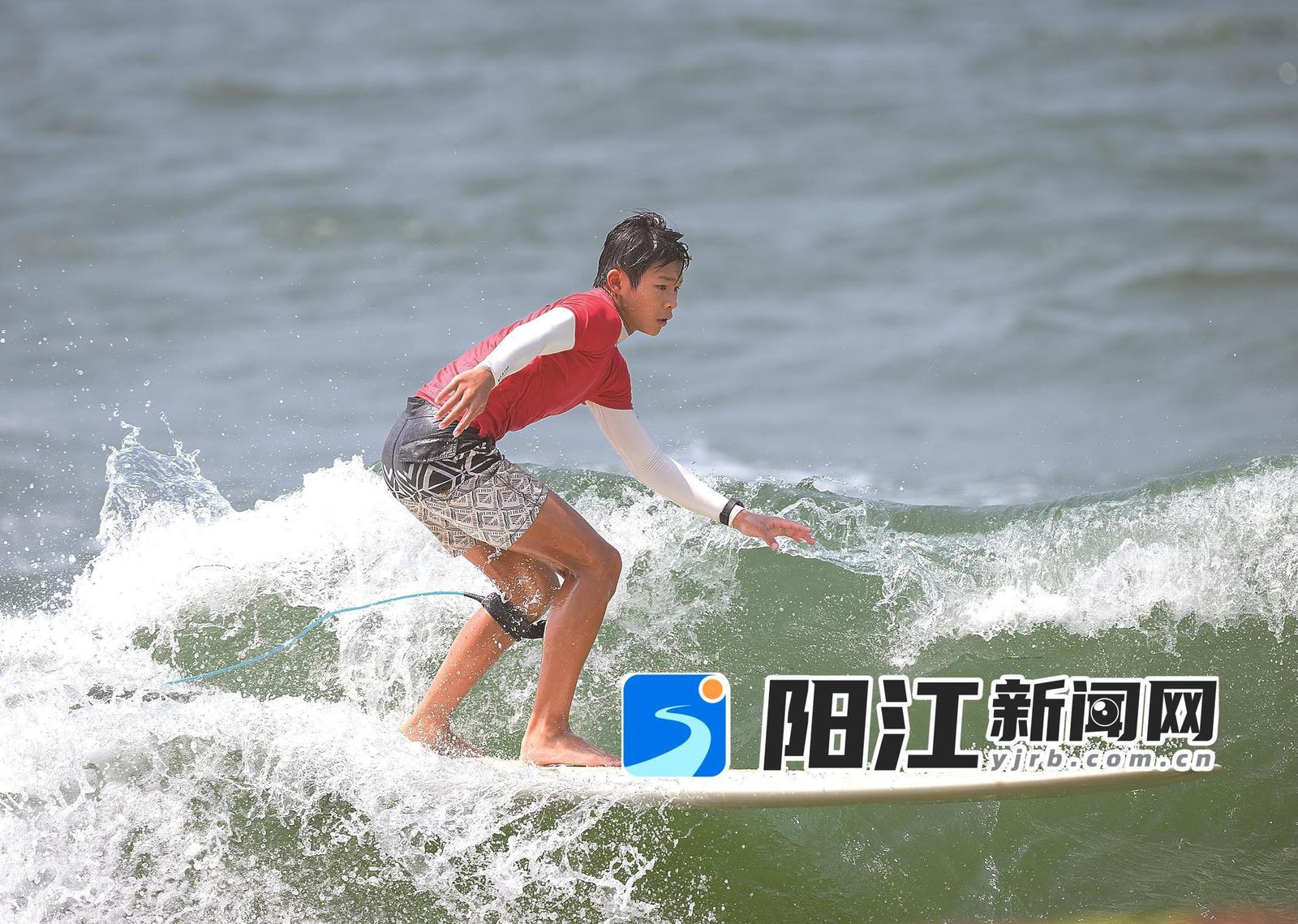 少年运动员脚踏冲浪板,在海面上乘浪飞驰。梁文栋 摄