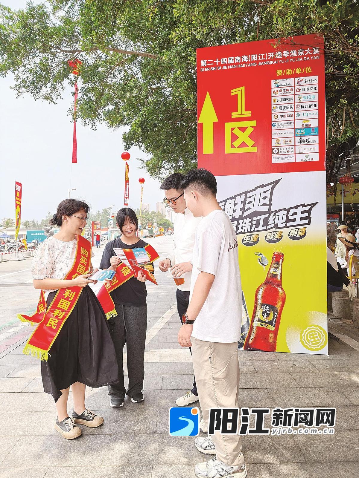 人民银行工作人员向游客派送宣传资料。人行阳江市分行提供