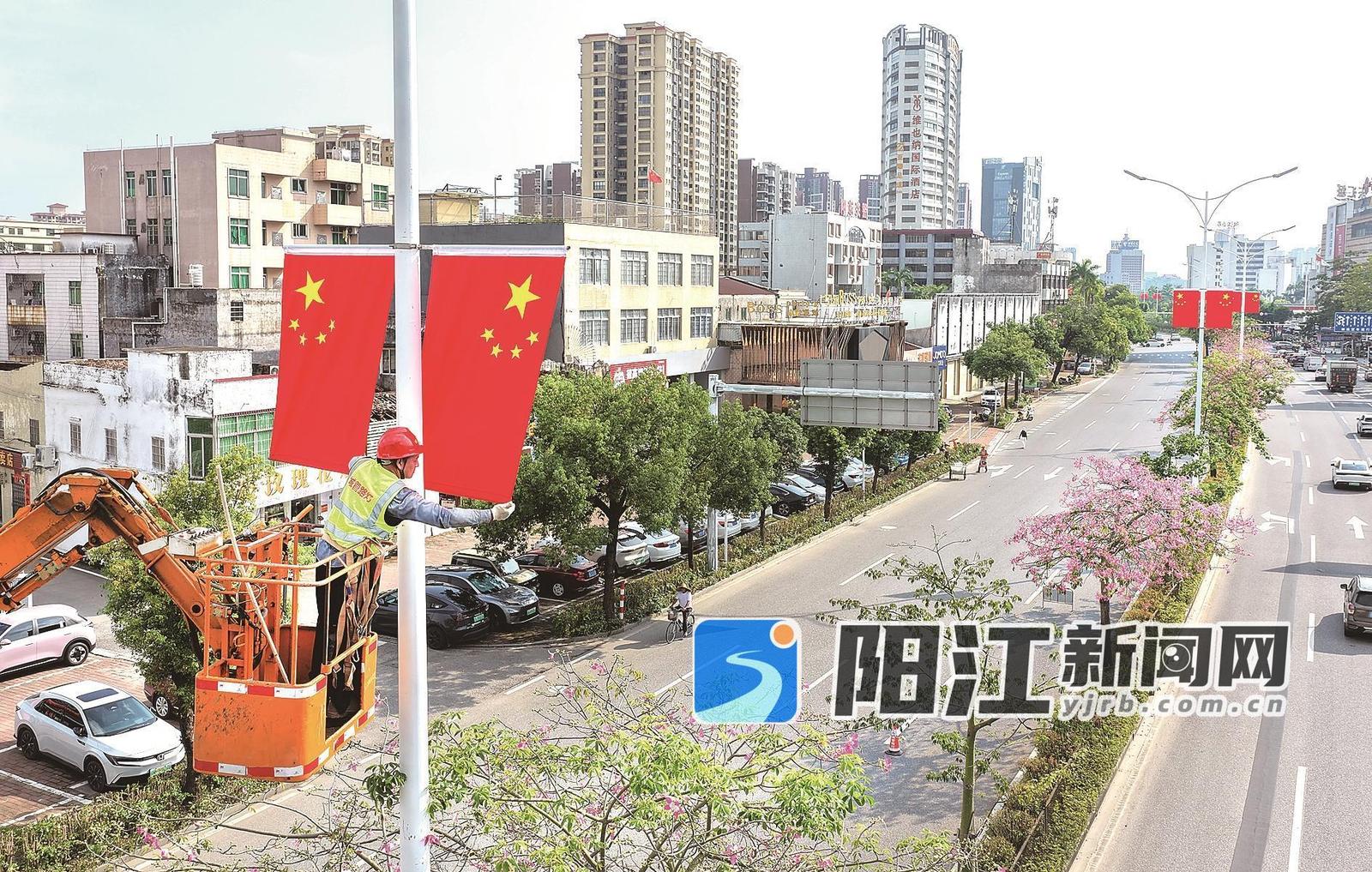 工作人员在市区东风三路悬挂国旗。梁文栋 摄